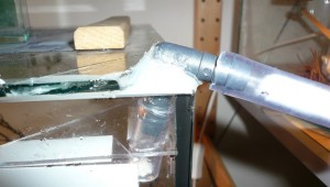 &quot;Ausgangspfusch&quot;: Da das Becken keine Bohrungen hat, befindet sich der Ausgang oben in einer Ecke. Ein Schlauchstück führt auch durch den Paraffinölrahmen. Aktuell ist der Ausgang übrigens zu.